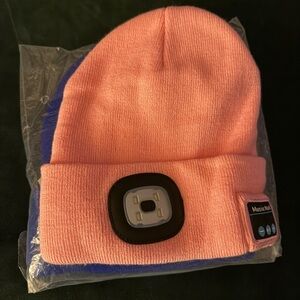 Pink and blue beanies with headlamp and bluetooth speakers